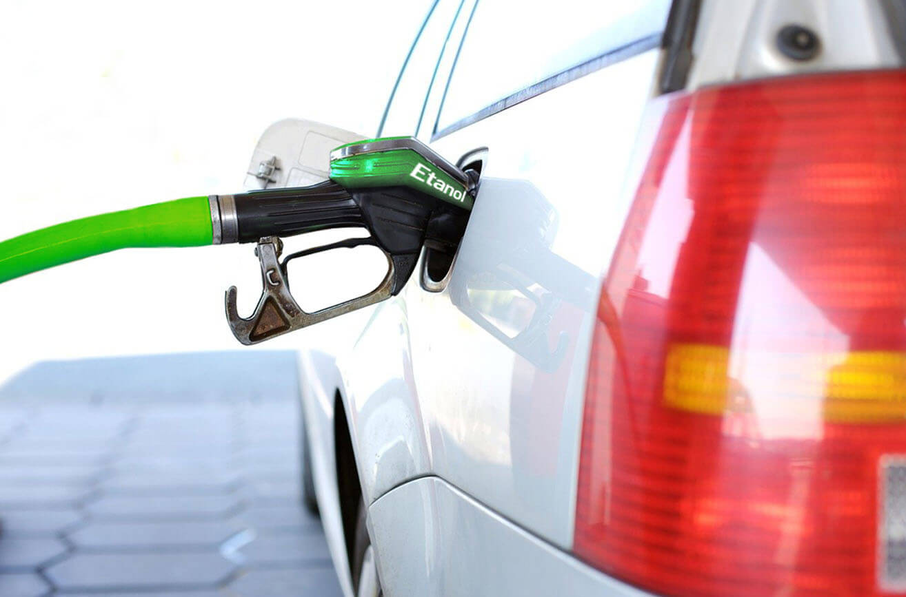 Veículo branco sendo abastecido com etanol em um posto de combustível