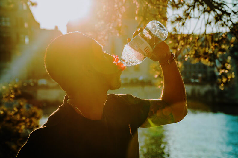 Imagem de uma pessoa bebendo água numa garrafa plástica para ilustrar que um estudo revela os perigos da ingestão de nanoplásticos presentes em líquidos