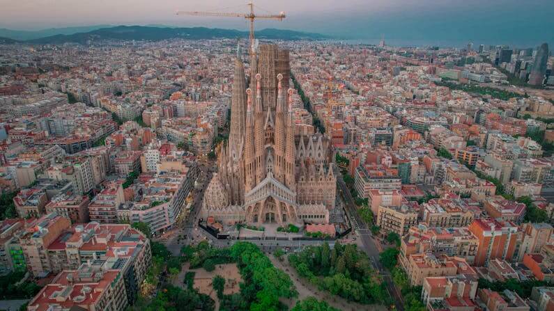 Imagem aérea da cidade de Barcelona mostrando a basílica no centro da foto ilustra o post cujo título diz que joia da arquitetura mundial demorou 144 anos para ser concluída.