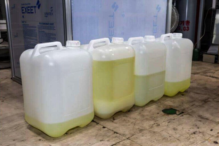 Imagem de bombonas de 20 litros com hidrocarbonetos líquidos ilustra o post sobre uma tecnologia que converte CO2 em gasolina numa planta-piloto.
