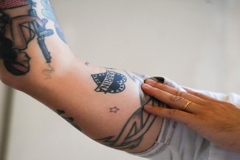 Imagem do braço de um homem com várias tatuagens ilustra o post cujo título diz que uma empresa lança a primeira tatuagem que não causa dor.