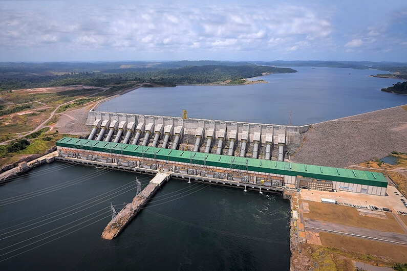 Imagem aérea da barragem de Belo Monte sob um céu azul claro e com várias nuvens ilustra o post sobre o dilema de Belo Monte e o conflito por água do rio Xingu.