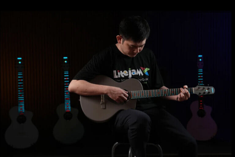 Imagem de um rapaz tocando guitarra ilustra o post cujo título diz que uma guitarra com LEDs RGB inteligentes ensina você a tocar.