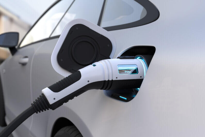 Imagem de um veículo elétrico sendo abastecido por um carregador ilustra o post cujo título diz: Carregadores para veículos elétricos – conheça todos os tipos.