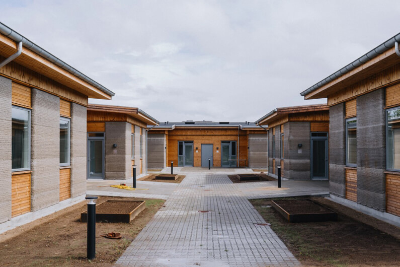 Imagem externa de casas impressas em 3D ilustra o post cujo título diz que um projeto habitacional impresso em 3D é o maior da Europa.