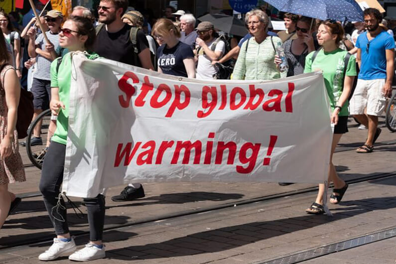 Imagem mostrando pessoas nas ruas segurando faixas em um protesto ambiental ilustra o post com o título: Do que as equipes de sustentabilidade devem se preparar.