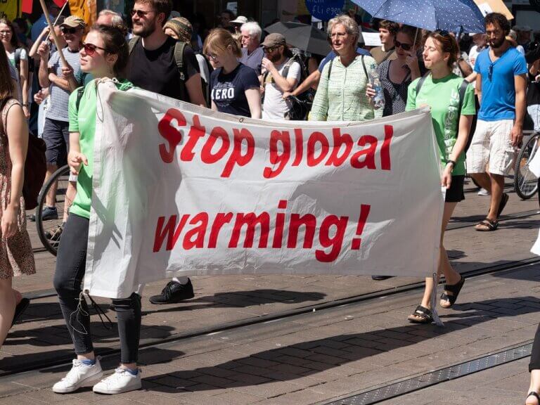 Imagem mostrando pessoas nas ruas segurando faixas em um protesto ambiental ilustra o post com o título: Do que as equipes de sustentabilidade devem se preparar.