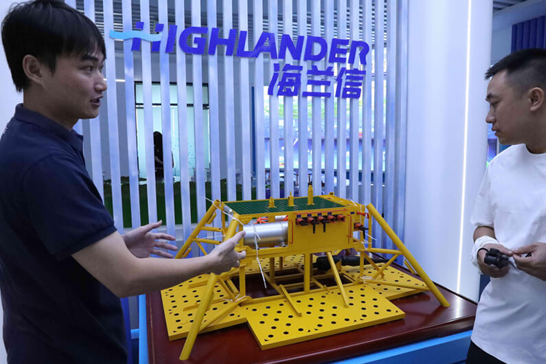 Imagem de dois rapazes diante de um projeto para data centers submersos ilustra o post cujo título diz que os data centers submersos no mar da China geram dúvida ambiental.